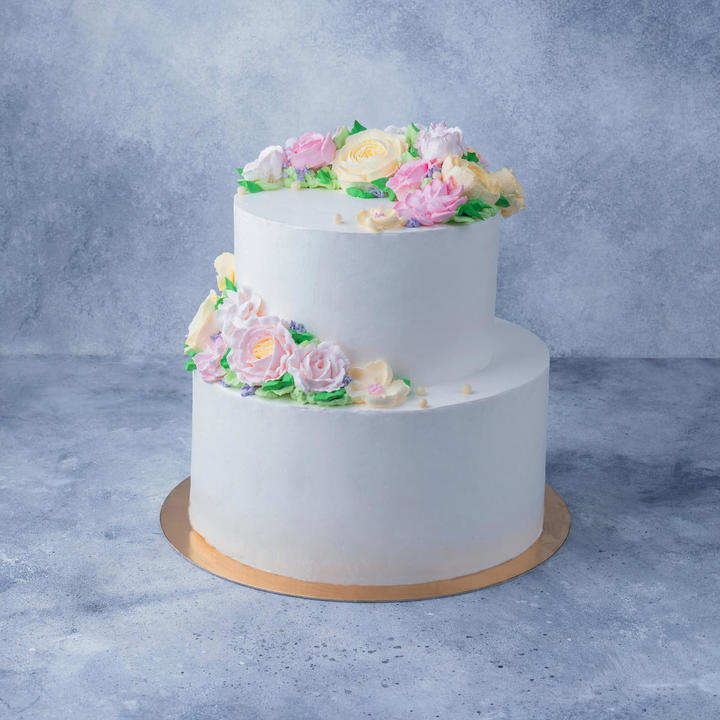 Белый двухъярусный торт с зеленым рисунком цветов